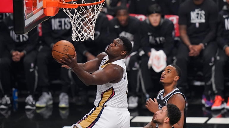 New Orleans Pelicans' Zion Williamson, left, drives past Brooklyn Nets'...