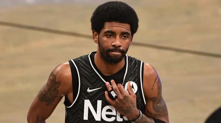 Nets guard Kyrie Irving looks on against the Phoenix Suns...