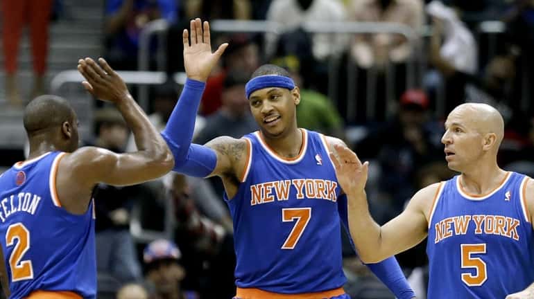 Knicks' Carmelo Anthony, center, high-fives teammates Raymond Felton, left, and...