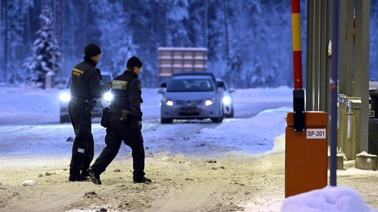 Finnish border guards walk at Vaalimaa border check point between...