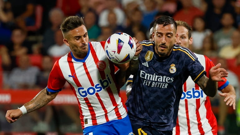 Girona's Aleix Garcia, left, duels for the ball with Real...