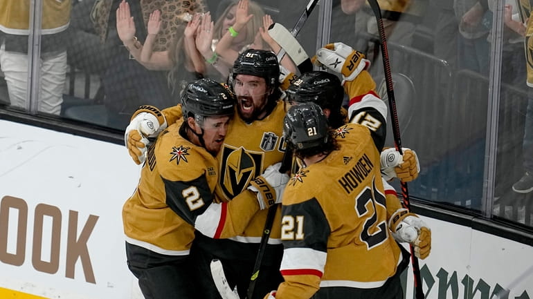 Vegas Golden Knights right wing Mark Stone, left, celebrates his...