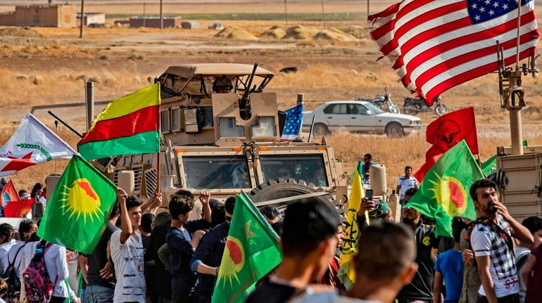 Syrian Kurds protest Sunday near a base for the U.S.-led...