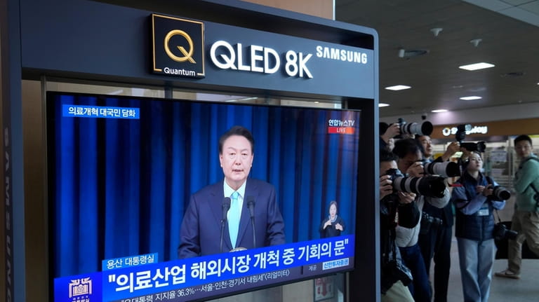 A TV screen shows the live broadcast of South Korean...