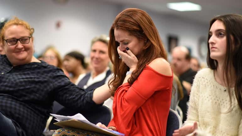 Parent Jennifer Boudin, center, of Melville, is brought to tears...