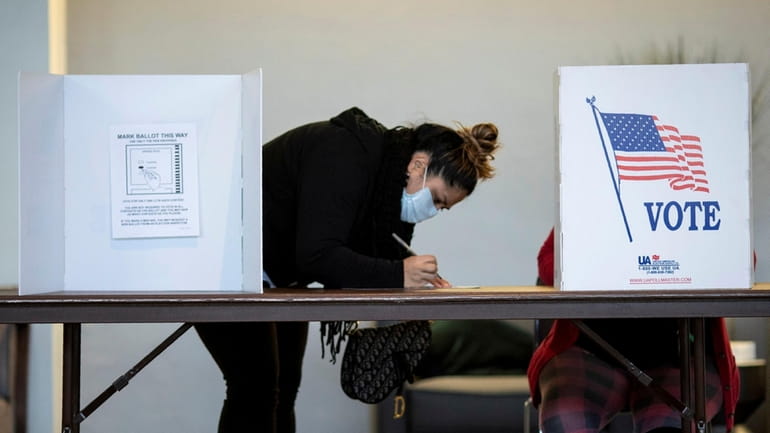 A voter marks her ballot on Election Day 2020 in...