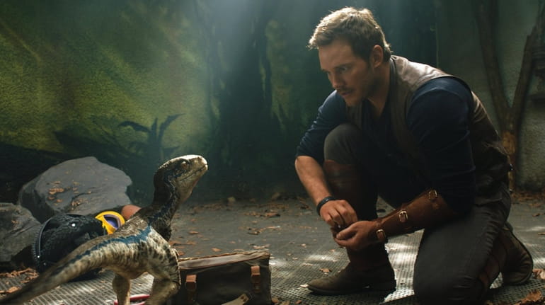 Chris Pratt appears in a scene with a young Velociraptor in "Jurassic...