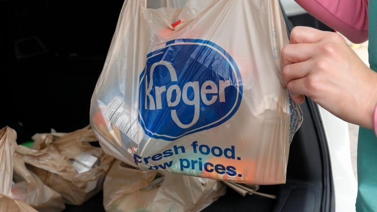 A customer removes her purchases at a Kroger grocery store...