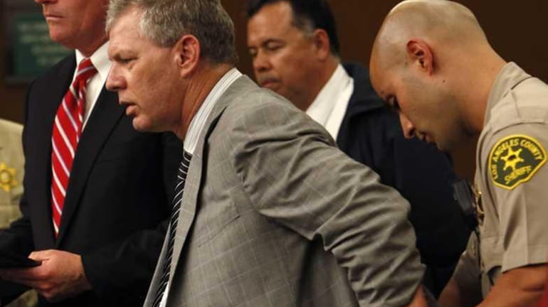 Lenny Dykstra is put in handcuffs after his arraignment on...