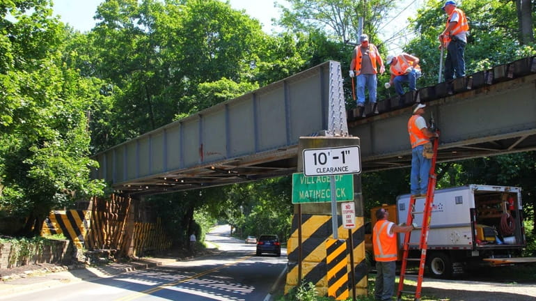 LIRR workers begin repair work on the bridge at the...