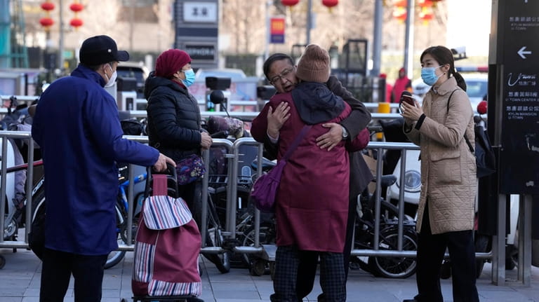 A man hugs a woman as family members of passengers...