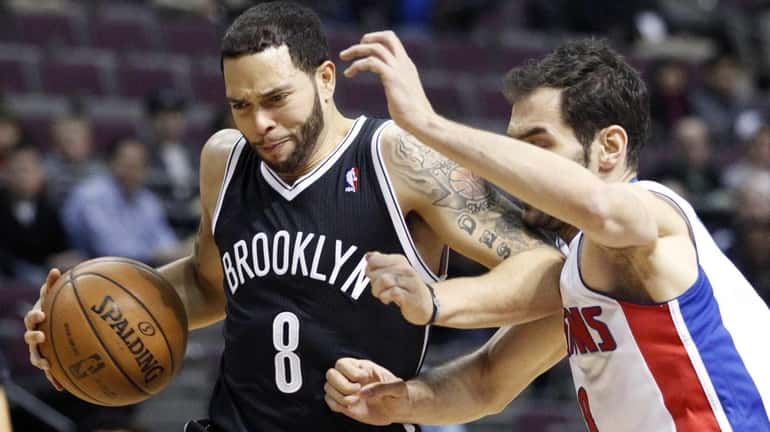 Deron Williams (8) is tightly guarded by Detroit Pistons' Jose...
