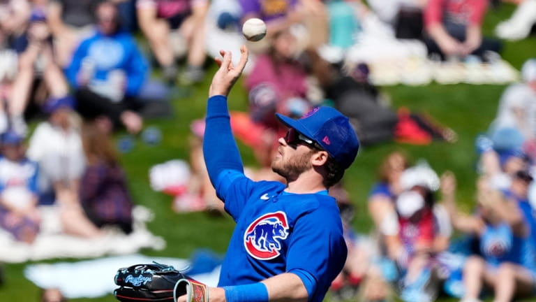 Chicago Cubs left fielder Ian Happ tosses a baseball into...