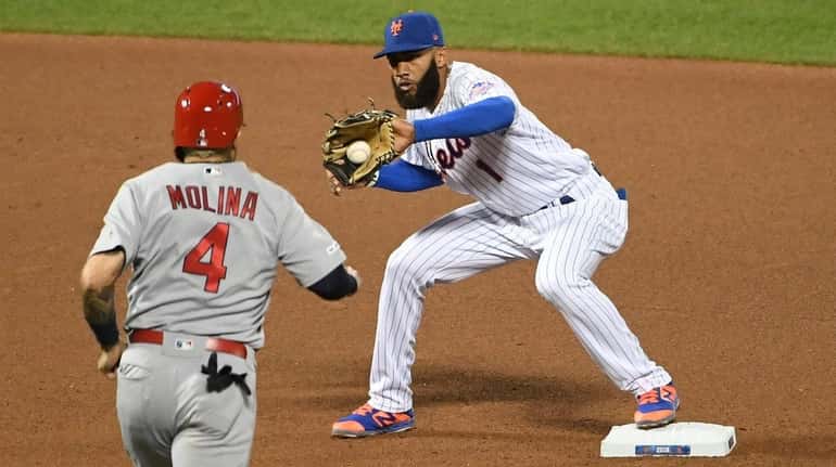 Mets shortstop Amed Rosario forces out Cardinals catcher Yadier Molina...