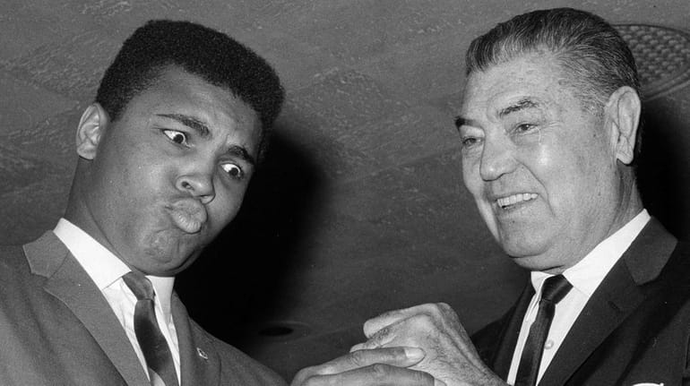 Heavyweight champion Muhammad Ali admires the fist of boxing great...