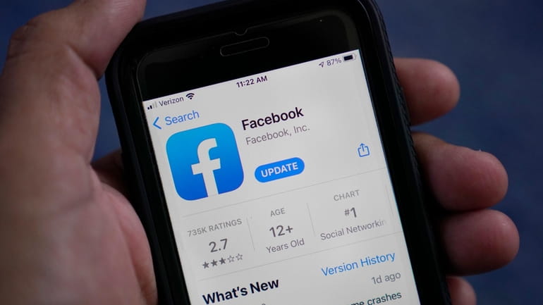 The Facebook app is shown on a smart phone in...