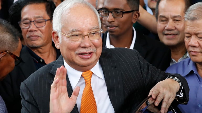 Former Malaysian Prime Minister Najib Razak waves as he leaves...