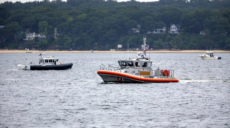 Search boats Saturday comb the waters of Northport Harbor after...