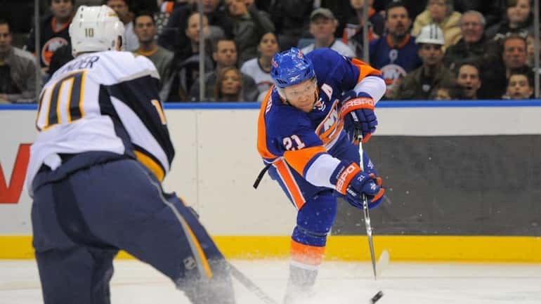 Islanders right wing Kyle Okposo, right, takes a shot on...