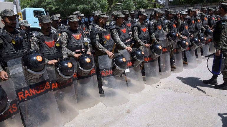 Troops with riot gear stand guard outside a court where Pakistan's...