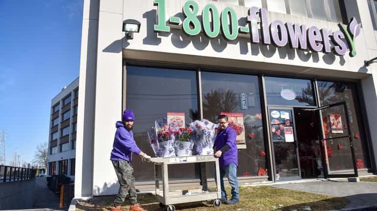 Stephen Williams, left and Walter Linares move Valentine's Day arrangements...