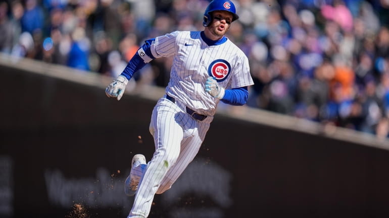 Chicago Cubs' Ian Happ runs the bases after hitting a...