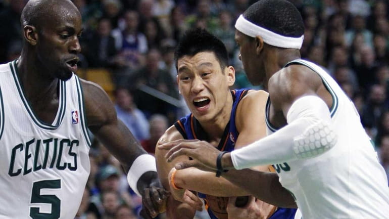 New York Knicks' Jeremy Lin, center, holds on to the...