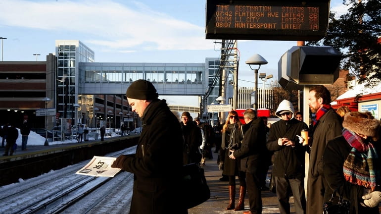 Commuters wait at the Mineola Long Island Rail Road station...