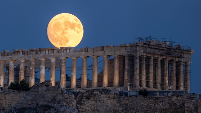 The moon rises in the sky behind the 5th century...