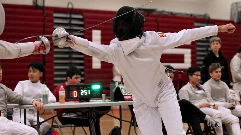 Ward Melville's Will Lehr, right, scores a point in his epee...