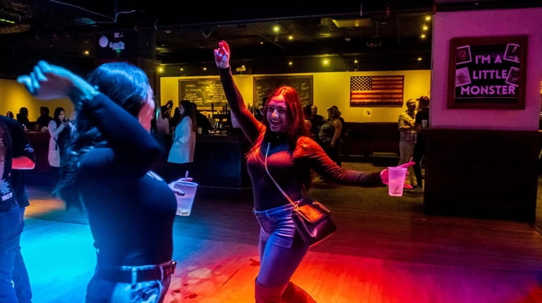 People dance as DJ Milli spins hit tunes of two...