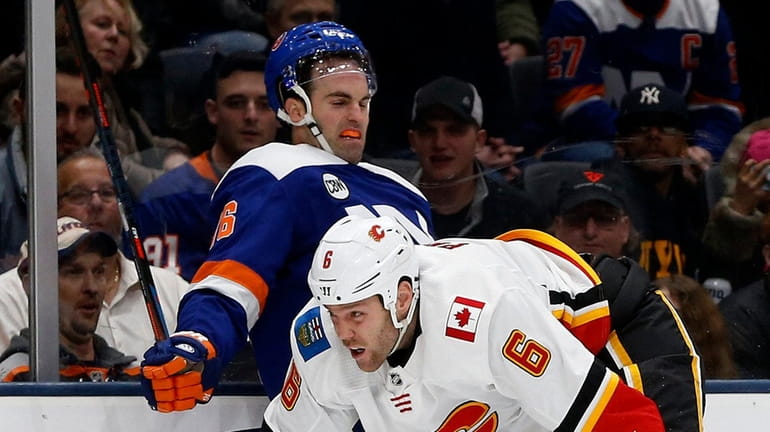 Dalton Prout of the Flames checks Andrew Ladd of the Islanders...