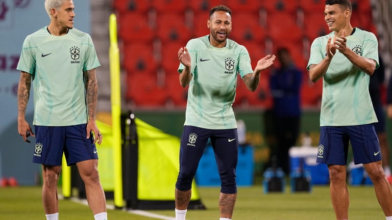 Brazil's Neymar, center, Pedro, left, and Thiago Silva exercise during...