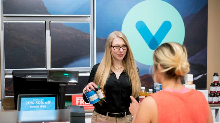 An employee rings up a customer at the Vitamin World...