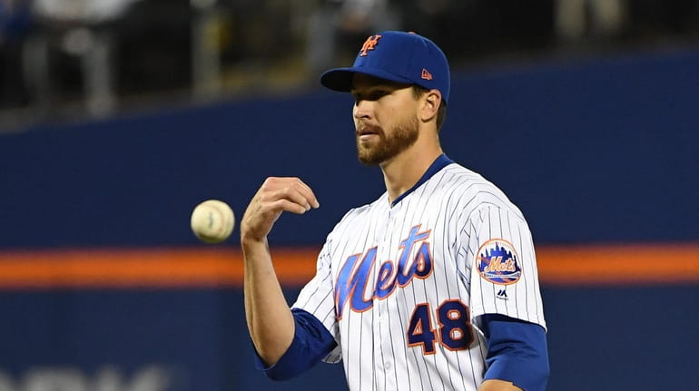 Mets starting pitcher Jacob deGrom reacts on the mound against...