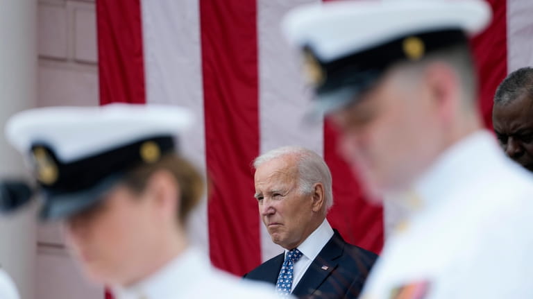 President Joe Biden stands with Defense Secretary Lloyd Austin as...