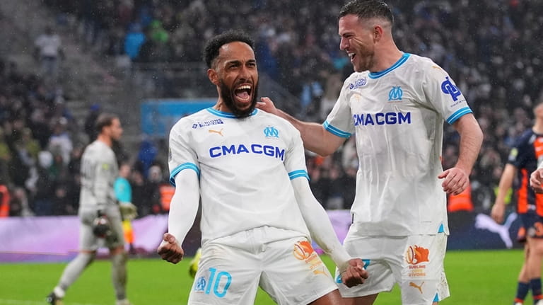 Marseille's Pierre-Emerick Aubameyang, left, celebrates after scoring his side's third...