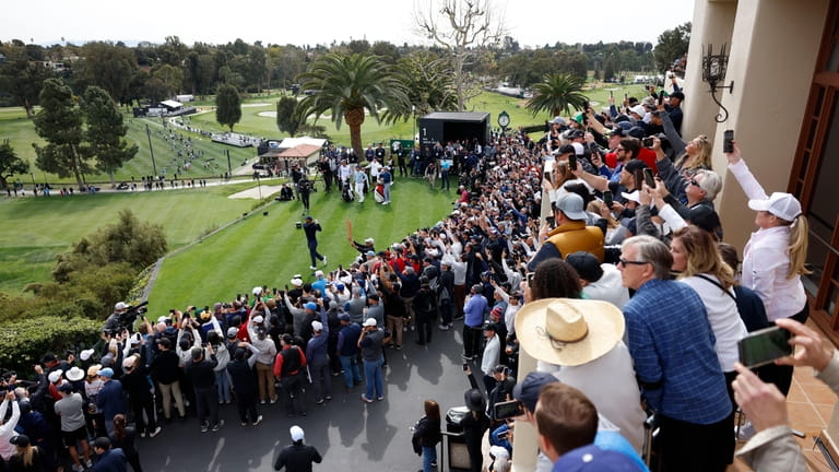 FILE - The gallery watches Tiger Woods as he hits...
