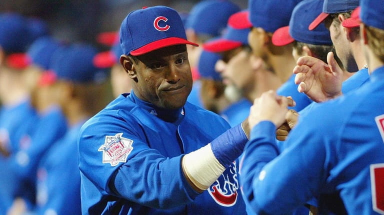 Sammy Sosa of the Chicago Cubs greets teammates during player...