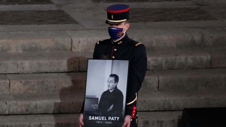 A Republican Guard holds a portrait of Samuel Paty in...
