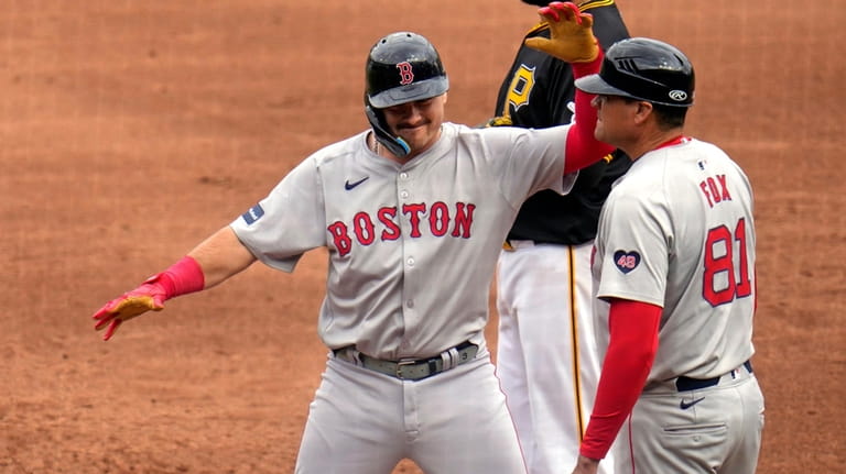 Boston Red Sox's Reese McGuire, left, celebrates on first base...