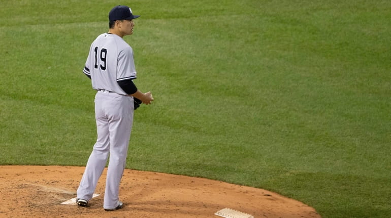 Yankees starting pitcher Masahiro Tanaka looks back after giving up...