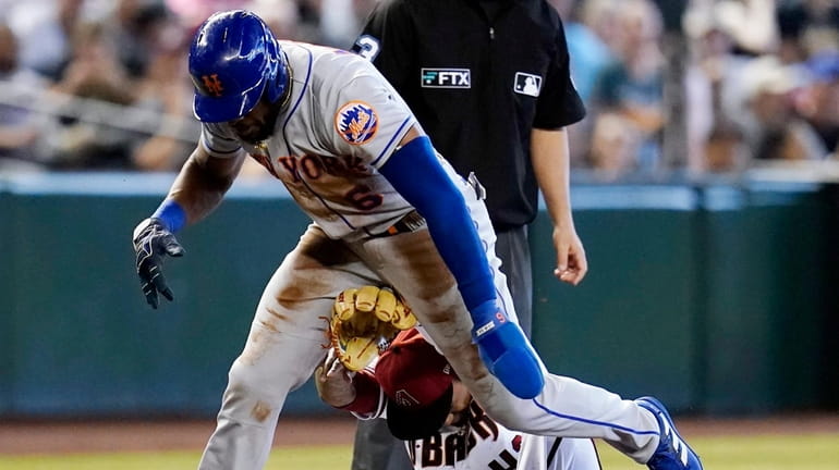 The Mets' Starling Marte hops over Diamondbacks third baseman Sergio Alcantara,...