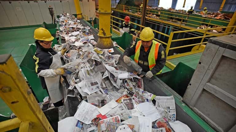 Workers at Green Stream Recycling perform quality control at the...