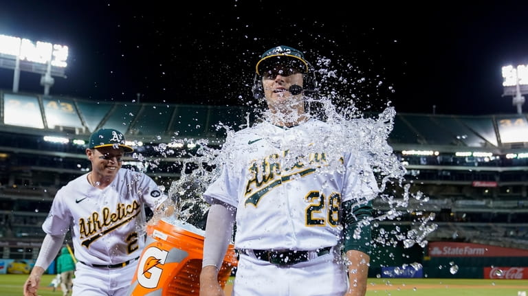Oakland Athletics' Nick Allen, left, douses Jonah Bride with iced...