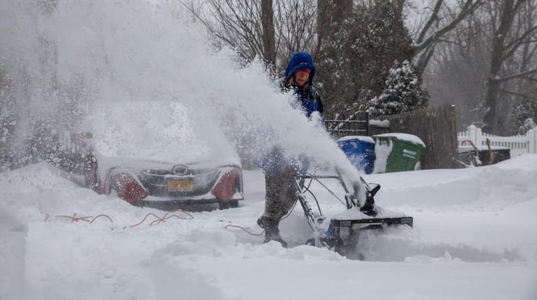 Johnna St. Clair of Port Jefferson snow blows her driveway during...