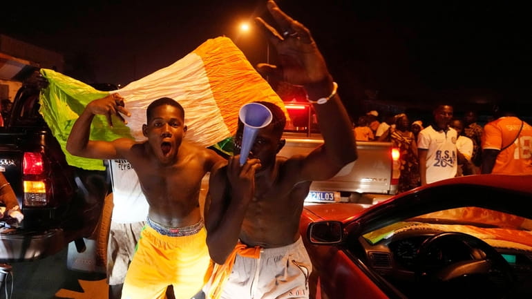 Ivory Coast soccer fans celebrate on a street in Bouake,...