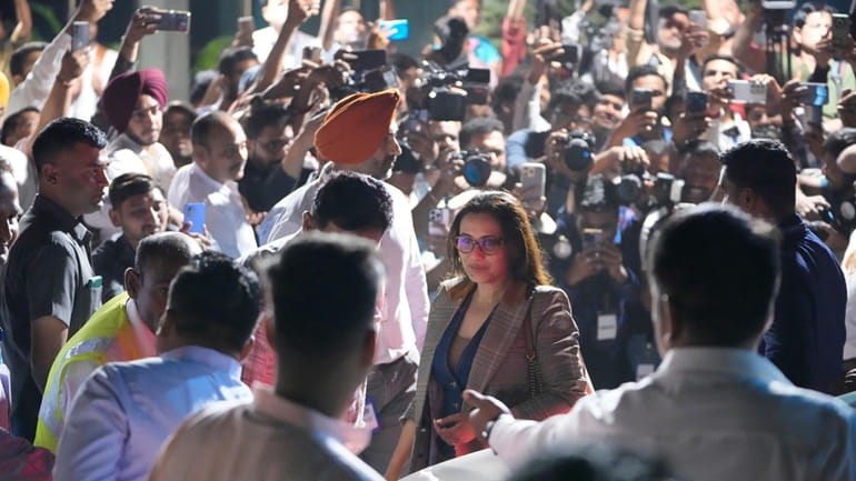 Bollywood actor Rani Mukherjee, center, wearing specs arrives at airport...