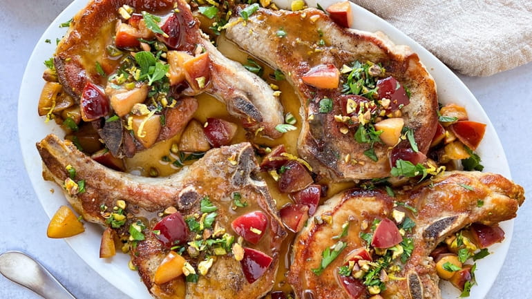 Spice rubbed pork chops are cooked with plums and topped...