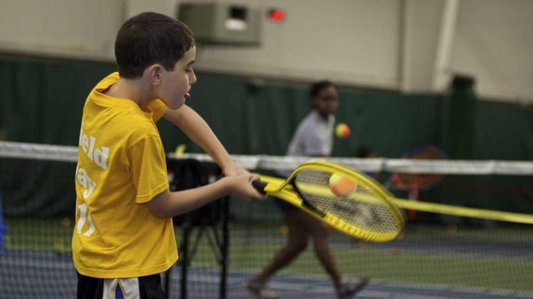8-year-old Gregory Weinstein takes a swing after spending a few...